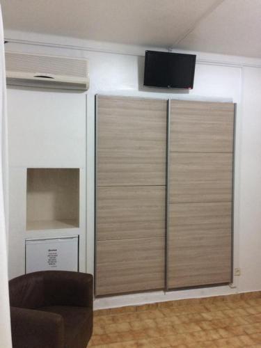 a room with a large closet with a tv on the wall at Hostel Boutique Marisol in Monte Gordo