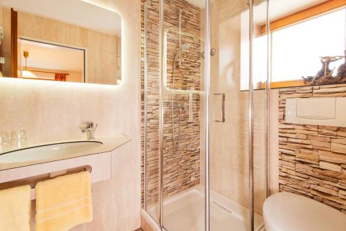 a bathroom with a shower and a toilet and a sink at Gästehaus Schmid in Obermaiselstein