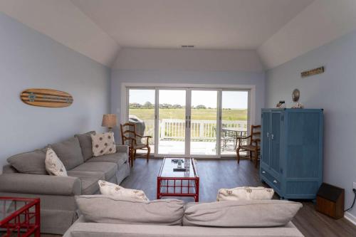 a living room with a couch and a table at Nautical Watch on Harbor Island in Oceanmarsh Subdivision