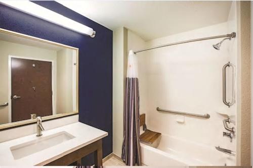 a bathroom with a tub and a sink and a mirror at La Quinta by Wyndham Wichita Northeast in Wichita