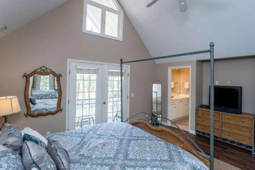 a bedroom with a bed and a mirror at Lloyd's Lodge at Davis Love Dr in Fripp Island