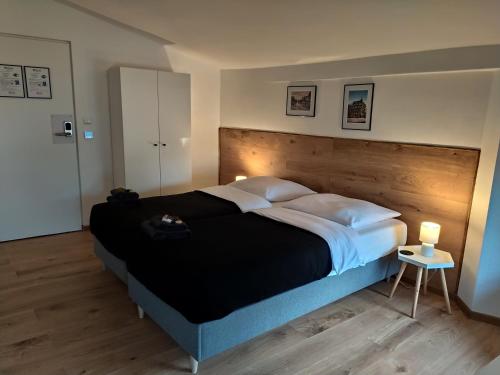 a bedroom with a large bed with a wooden headboard at OficynaApartments in Gliwice