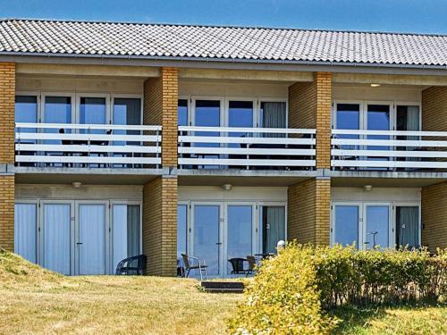 a building with a balcony with tables and chairs at 4 person holiday home in Allinge in Allinge