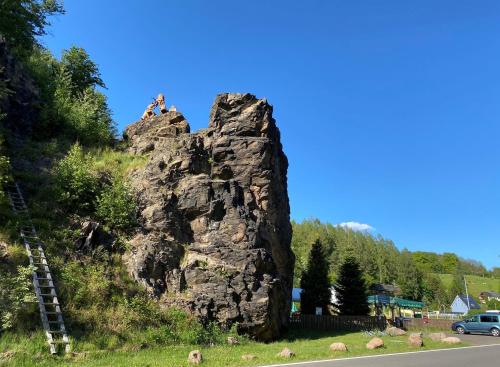 a person sitting on top of a rock on the side of a road at Berghotel Talblick in Holzhau