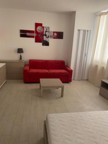 a living room with a red couch and a coffee table at senza pensieri via 4 novembre/via diaz in Crema