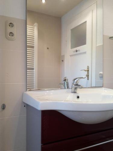 a bathroom with a white sink and a mirror at Ferienwohnung Dresden West in Dresden