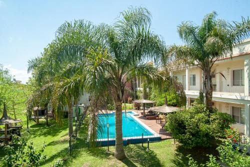 una imagen de una piscina en un hotel con palmeras en Hotel y Spa Termas del Este en Federación