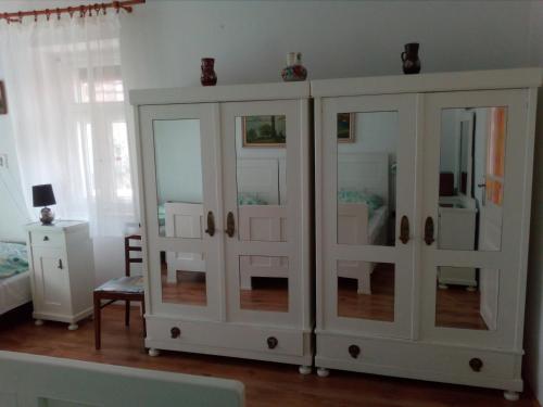 a white cabinet with glass doors in a room at Nosztalgia Vendégház in Bogács