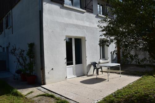 a table and a chair in front of a building at Gite de Grigny in Éclaires