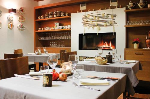 a restaurant with two tables with wine glasses and a fireplace at Locanda Montegrappa in Borso del Grappa