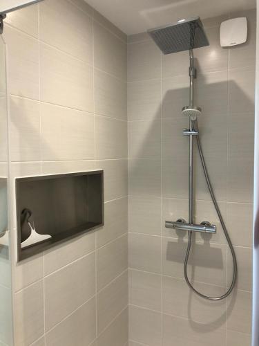 une douche avec pommeau de douche dans une salle de bain dans l'établissement Appartement 