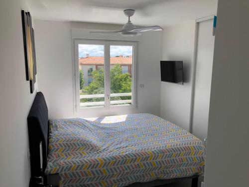 a bedroom with a bed and a window at Appartement "Envies D'ailleurs" Vue Mer in Saint-Brevin-les-Pins
