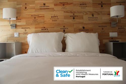 a white bed with a sign in front of it at Decanting Porto House in Porto