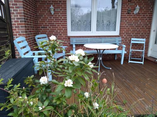 a patio with a table and chairs on a deck at Charmantes Ferienhaus in Nordfriesland in Humptrup