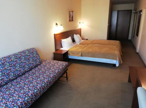 a hotel room with two beds and a couch at Hotel Adria in Rumia