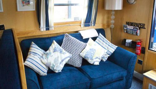 a blue couch with several pillows on it at Houseboat Hotels in Sheffield