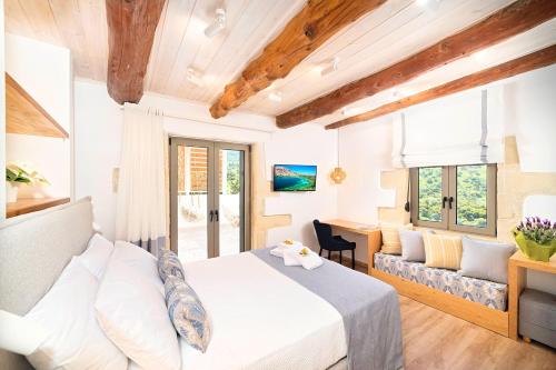 a bedroom with a white bed and a couch at Blue Lake Villa Heated Pool in Georgioupoli