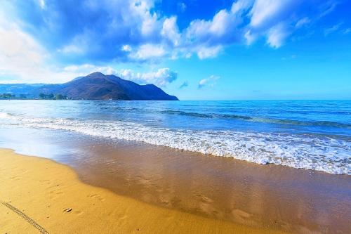 a beach with the ocean and a mountain in the background at Blue Lake Villa Heated Pool in Georgioupoli