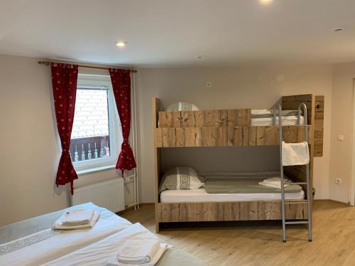 a bedroom with two bunk beds and a window at Guesthouse Veranda in Mojstrana