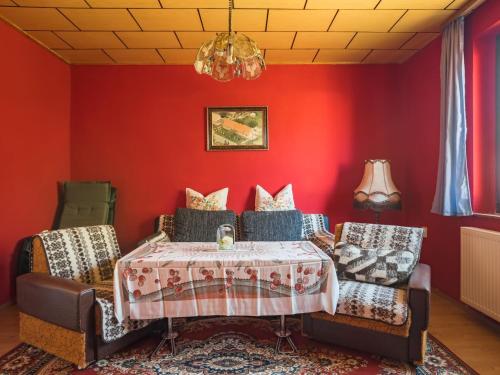 a dining room with red walls and a table and chairs at Alluring Holiday Home in Meisdorf with Garden in Meisdorf