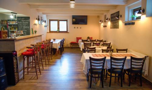 a restaurant with tables and chairs and a bar at Penzion Bezděkov in Rakovník
