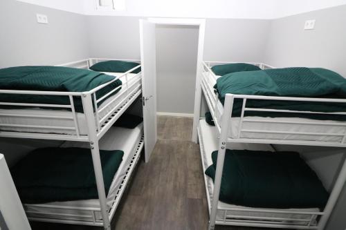 a room with three bunk beds with green sheets at Madrid Downtown Hostel in Madrid