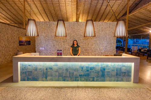 a woman standing in front of a counter in a room at Manati in Barra Grande