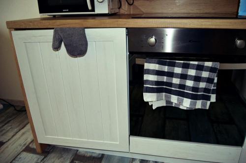 a kitchen counter with a microwave and a dishwasher at U starého jaštera in Veľká Lomnica