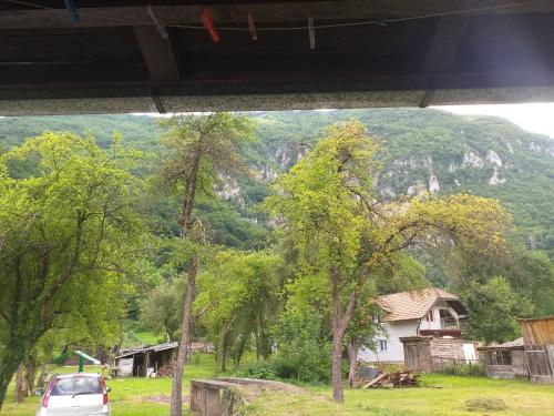 a car parked in front of a house with a mountain at Vikendica Iva in Perućac