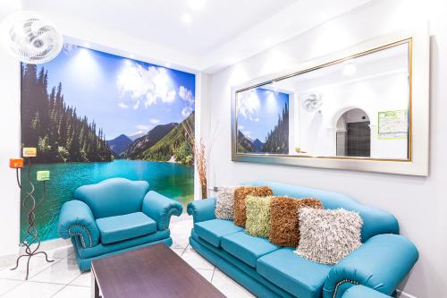 a living room with blue furniture and a painting on the wall at Hotel El Deportista in Medellín