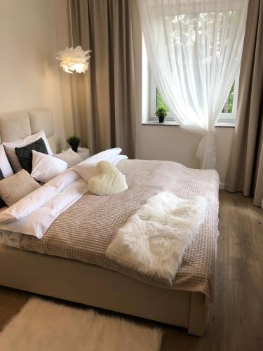 a bedroom with a bed with white blankets and pillows at Apartamenty Pod Gwiazdami in Ustroń