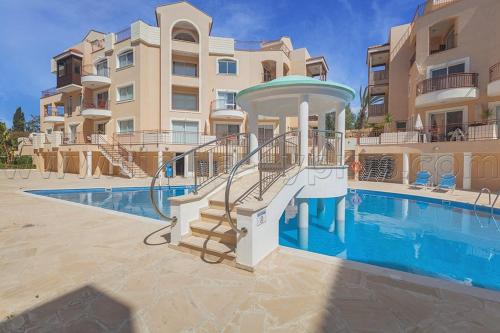 a swimming pool in front of a apartment building at Pafilia Garden Apartments in Paphos