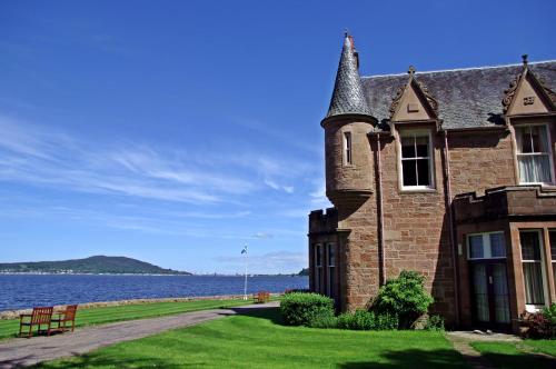 an old brick building next to a body of water at Bunchrew House Hotel in Inverness