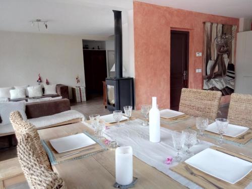 une salle à manger avec une table, des chaises et une cheminée dans l'établissement Maison Cosy Lac d'Annecy, à Talloires