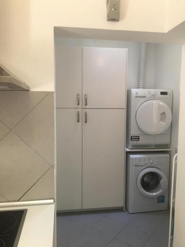 a kitchen with a washing machine and a washer at 3 Bedroom Town House - Historic Centre of Cascais. 100 mts from the beach and centre of Cascais in Cascais
