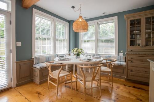 a dining room with a white table and chairs at The Bungalow in Nantucket