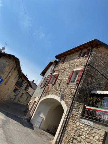 a large stone building with an archway on a street at B&B Antiche Mura in Puegnago