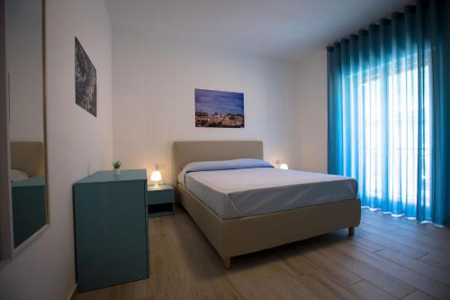 a bedroom with a bed and a dresser and a window at Casa Vacanza Barone in Castellammare del Golfo