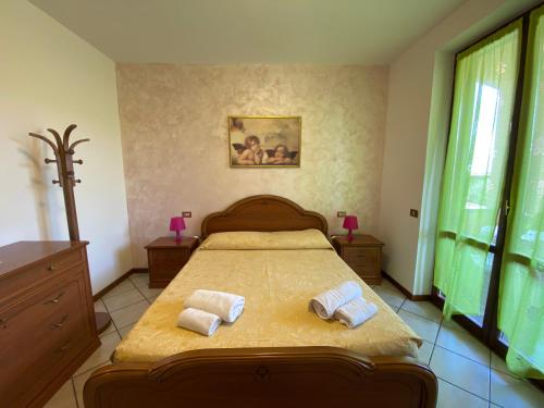 1 dormitorio con 1 cama con 2 toallas en B&B Nonna Cecilia, en Puegnago sul Garda