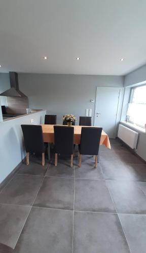 a dining room with a table and chairs at Vakantiehuis 't Wijngaardje in Merkem
