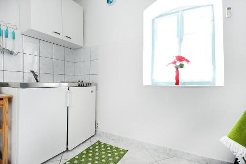una cucina con lavandino e una finestra con ombrellone di Apartments Rejo a Okrug Donji