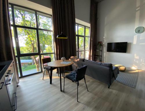 een woonkamer met een bank en een tafel bij G - Owl Jazz -Modern loft type apartment 18 with big roof terrace and free private parking in Kaunas