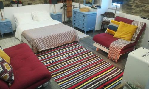 a bedroom with a bed and two chairs and a rug at A Tasca in Vila Real