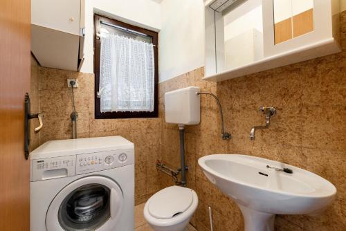 a bathroom with a washing machine and a sink at Apartment Vinez in Labin