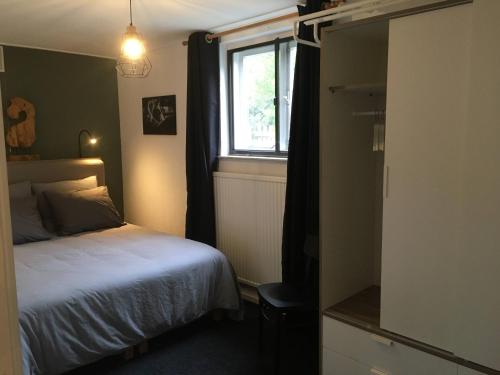 Habitación pequeña con cama y ventana en Vakantieappartement Stal Rhosyr, en Laren