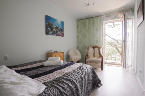 1 dormitorio con 1 cama, 1 silla y 1 ventana en roomsy Chopina en Sopot