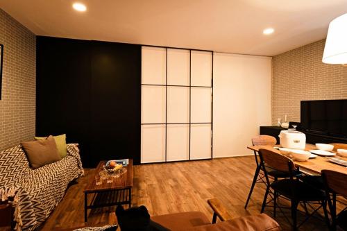 a living room with a table and a couch at One living in 24 - Vacation STAY 83393 in Sapporo