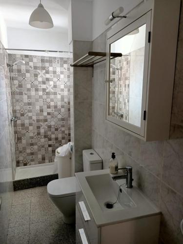 a bathroom with a sink and a toilet and a mirror at Casa Mary in Granadilla de Abona