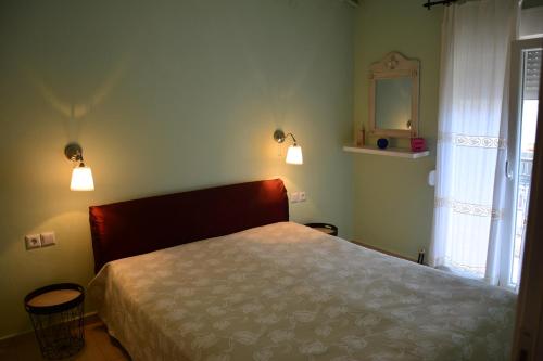 ネア・ムダニアにあるMoudania's cozy apartmentのベッドと鏡と窓のある寝室