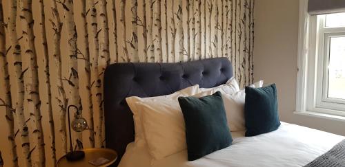 a bedroom with a bed with a blue headboard and pillows at The Coal Merchant's House in Whitby